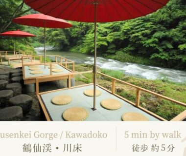 Riverside kawadoko platforms with red parasols at Shirasagiyu Tawaraya in Ishikawa, Chūbu