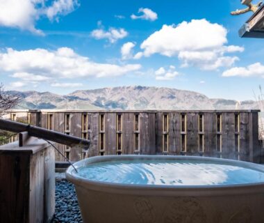 Outdoor onsen tub with wooden fence and distant mountain view at Shirayunoyado Yamadaya, Hakone, Kanagawa