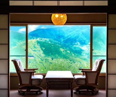 Tatami room with low table and chairs at Shirayunoyado Yamadaya overlooking Hakone mountains