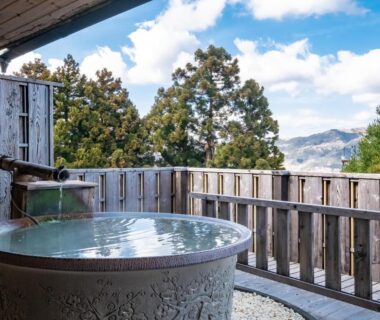 Round outdoor bath on wooden terrace at Shirayunoyado Yamadaya Hakone, treed hillside view, Kanagawa
