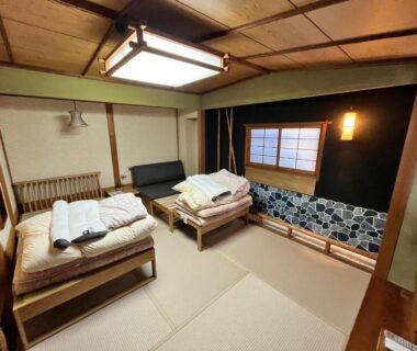 Traditional tatami room with futon bedding on raised wooden platforms, shoji window and low seating at Shiroyama Ryokan, Nara