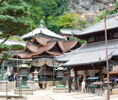 Shinto shrine courtyard with stone lanterns featured for Shiroyama Ryokan in Nara, Kansai