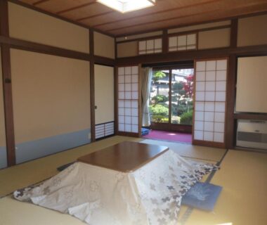 Traditional tatami room with kotatsu and shoji doors opening to garden at Shitanda in Gifu, Chūbu