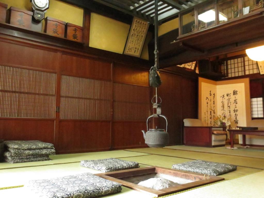 Tatami Room with Irori at Shitanda Gifu Traditional tatami room with sunken irori hearth, hanging kettle, floor cushions and wooden shoji interiors at Shitanda, Gifu