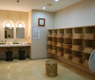 Dressing room with mirrors, sinks, wooden baskets and stools in a ryokan at Shiunso, Kanagawa