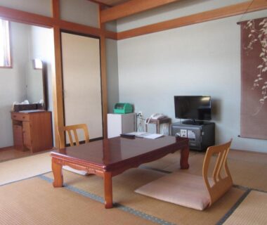 Traditional tatami room with low table, zaisu chairs, TV and sliding doors at Shiunso in Tochigi, Kanto