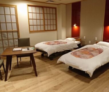 Two single beds, wooden floor, shoji screens and low table in Shizukatei room, Iwate Tōhoku