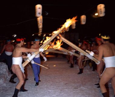 Men in loincloths crossing flaming torches during a snowy winter festival near Shizukatei, Iwate Tōhoku