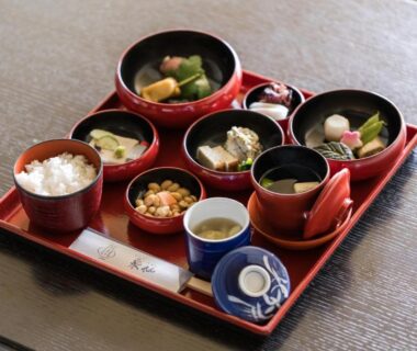 Lacquered tray with assorted traditional Japanese breakfast dishes including rice, soup, pickles and simmered vegetables