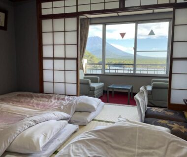 Traditional tatami room with futon bedding and shoji screens overlooking a mountain view in Yamanashi