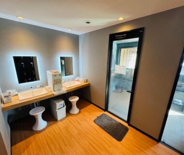 Double vanity with stools and mirrors, glass door leading to bathing area at Shoji Lake Hotel, Yamanashi