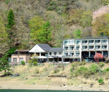 Multi-story lakeside ryokan building on wooded hillside at Shoji Lake Hotel, Yamanashi, Chūbu