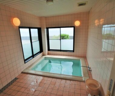 Enclosed tiled bathing room with indoor tub and windows at Shokinkan in Kumamoto, Kyūshū