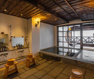 Traditional indoor wooden bath with washing stools and balcony at Shorenkan Yoshinoya in Kyoto