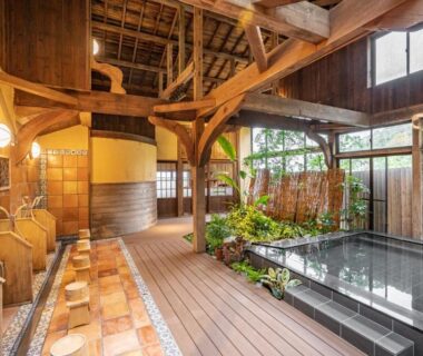 Indoor wooden onsen bath with wash stations, stools, soaking pool and timber beams at Shorenkan Yoshinoya, Kyoto