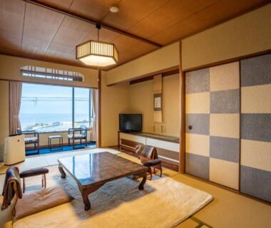 Traditional tatami room with low wooden table, zabuton cushions, shoji screens and seaside view at Shorenkan Yoshinoya, Kyoto