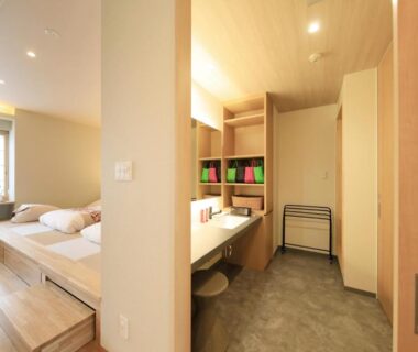 Bright wood interior with raised tatami platform, twin beds, vanity sink, and shoji window at Shouhakutei Azumaso