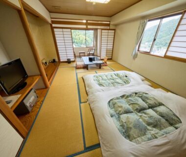 Tatami room with futon bedding, low table, shoji screens and window with greenery, Shuzenji Onsen Hotel Takitei Shizuoka