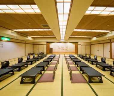 Large tatami dining hall with low tables and floor cushions at Shuzenji Onsen Hotel Takitei in Shizuoka