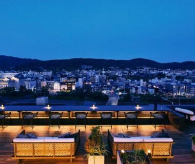 Rooftop cabins and seating at Sora Niwa Terrace overlooking Kyoto city skyline at dusk
