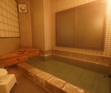 Small indoor tiled bath with wooden bench and washing stool at Soumeian in Gunma, Kantō