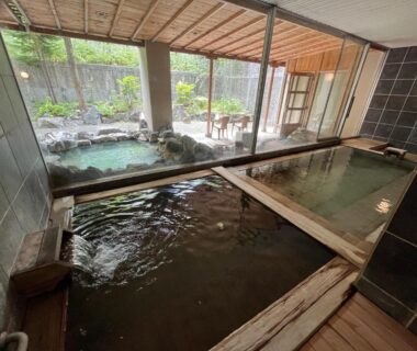 Indoor wooden and stone onsen baths with garden view at Spa and Esthetique Suichokan, Hokkaidō, female and adult only