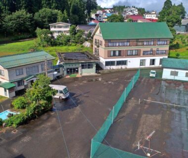 Aerial view of Sports Plaza Shiki Haradaso with fenced sports courts and surrounding greenery in Niigata