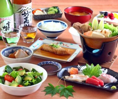 Assorted Japanese dishes with sashimi, rice, soup and sake at Sports Plaza Shiki Haradaso, Niigata