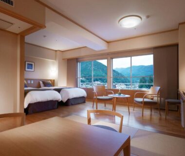 Tatami room with twin beds, low table and mountain view at Suimeikan Gifu Chubu