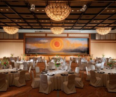 Spacious banquet room with round tables and chandeliers at Suimeikan in Gifu