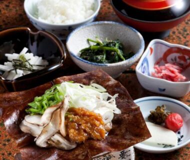 Assorted small dishes with rice and lidded soup bowl, grilled item on tabletop brazier at Suisensou in Gifu, Chūbu, Japan