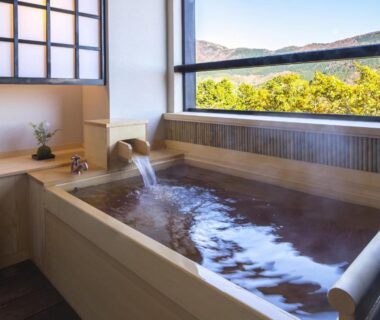 Indoor wooden soaking tub with flowing spout and mountain view at Suiun in Kanagawa, Kantō, Japan