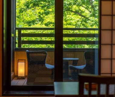 Interior with shoji screen, balcony chairs and verdant trees at Suiun, Kanagawa, Japan