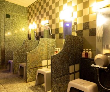 Tiled communal wash stations with stools, mirrors and toiletries in a ryokan bathing area at Suizansou, Hyōgo, Kansai