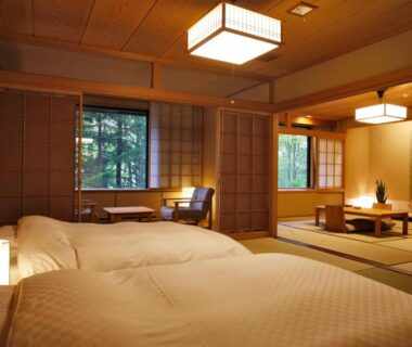 Japanese tatami room with twin futon beds, shoji screens, low table and garden view at Suizantei Club Jozankei in Hokkaidō