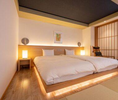 Tatami room with low platform twin beds, shoji screen and warm lighting at Suminoyu in Nagano, Chūbu