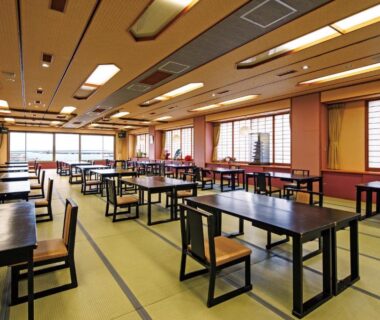 Spacious tatami dining room with low tables, chairs and shoji screens at Sumiyoshiya in Niigata