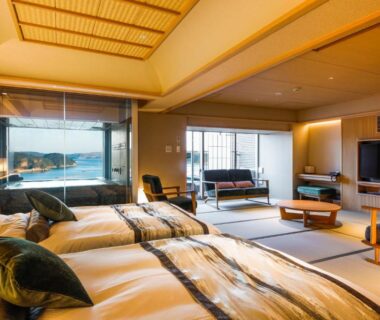 Spacious tatami room with two beds, seating area and large window at Sun Urashima Yuki no Sato Mie
