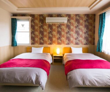 Twin beds with red runners, bedside lamp and patterned wall at Sundance Resort Hakone Gora, Kanagawa Japan
