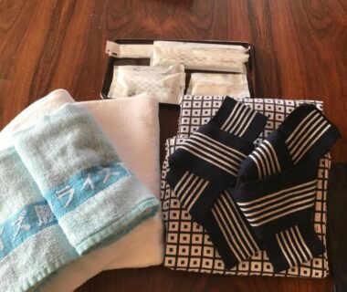 Folded towel, hand towel and yukata with sash on wooden table at Sunrise Katsuura Wakayama