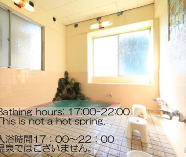 Small tiled bathing area with frosted window and signage at Sunrise Meiji-ya, Nagano, Chūbu