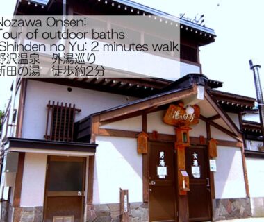 Entrance of Sunrise Meiji-ya with wooden beams, noren curtains and tiled roof in Nagano