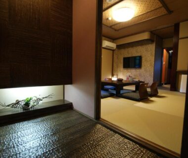 Stone genkan leading to tatami room with low table and zabuton at Yado Kanzan, Gunma