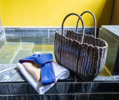 Woven basket and folded robe beside tiled onsen bath at Susukinohara Ichinoyu in Kanagawa