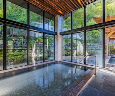 Indoor onsen bath room with floor-to-ceiling windows overlooking garden at Susukinohara Ichinoyu Kanagawa