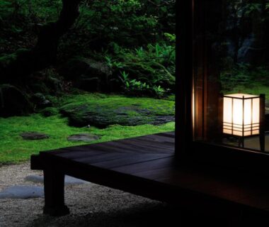 Wooden veranda with glowing lantern overlooking moss garden at Suwa Grand Shrine Kameya Inn, Nagano