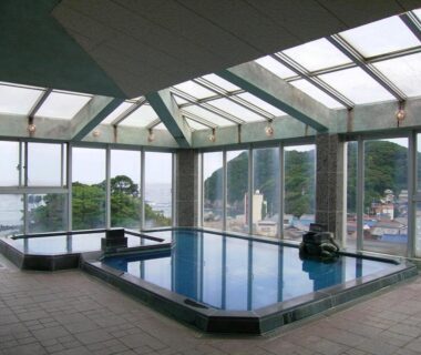 Glass-roofed indoor onsen bath with panoramic sea view at Suzunami, Mie, Kansai