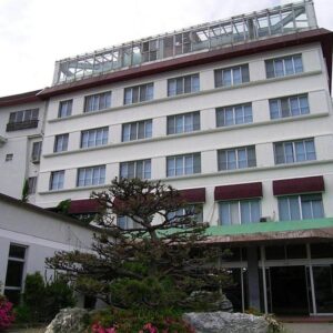 Multi-story ryokan building with entrance and small landscaped garden at Suzunami in Mie, Kansai