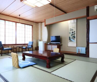 Traditional tatami room with low table, zabuton cushions, shoji screens and tokonoma at Suzunami in Mie