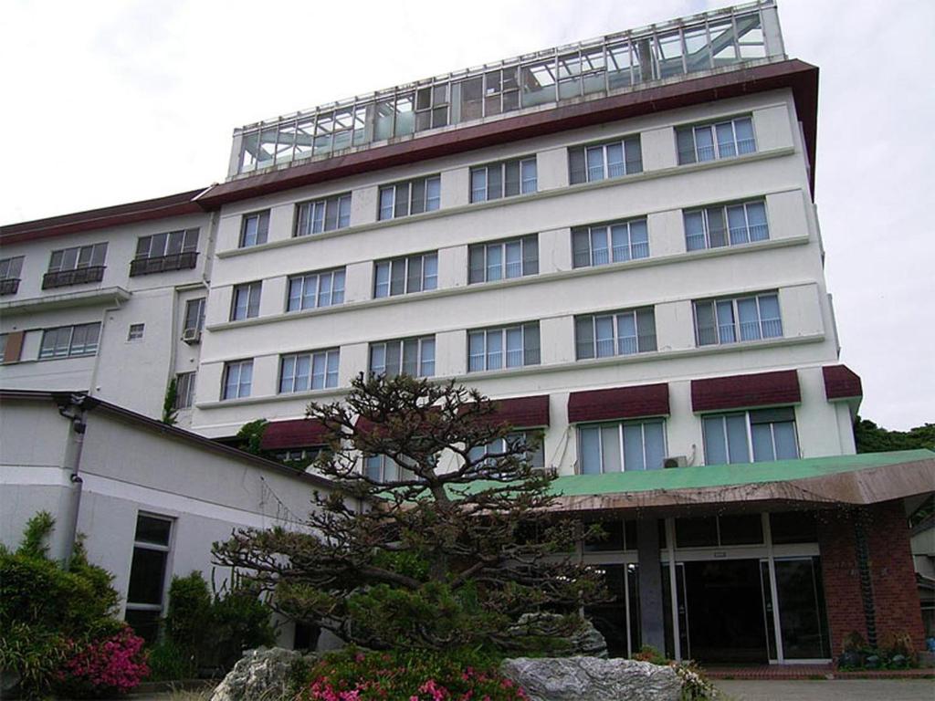 Ryokan exterior at Suzunami in Mie Multi-story ryokan building with entrance and small landscaped garden at Suzunami in Mie, Kansai